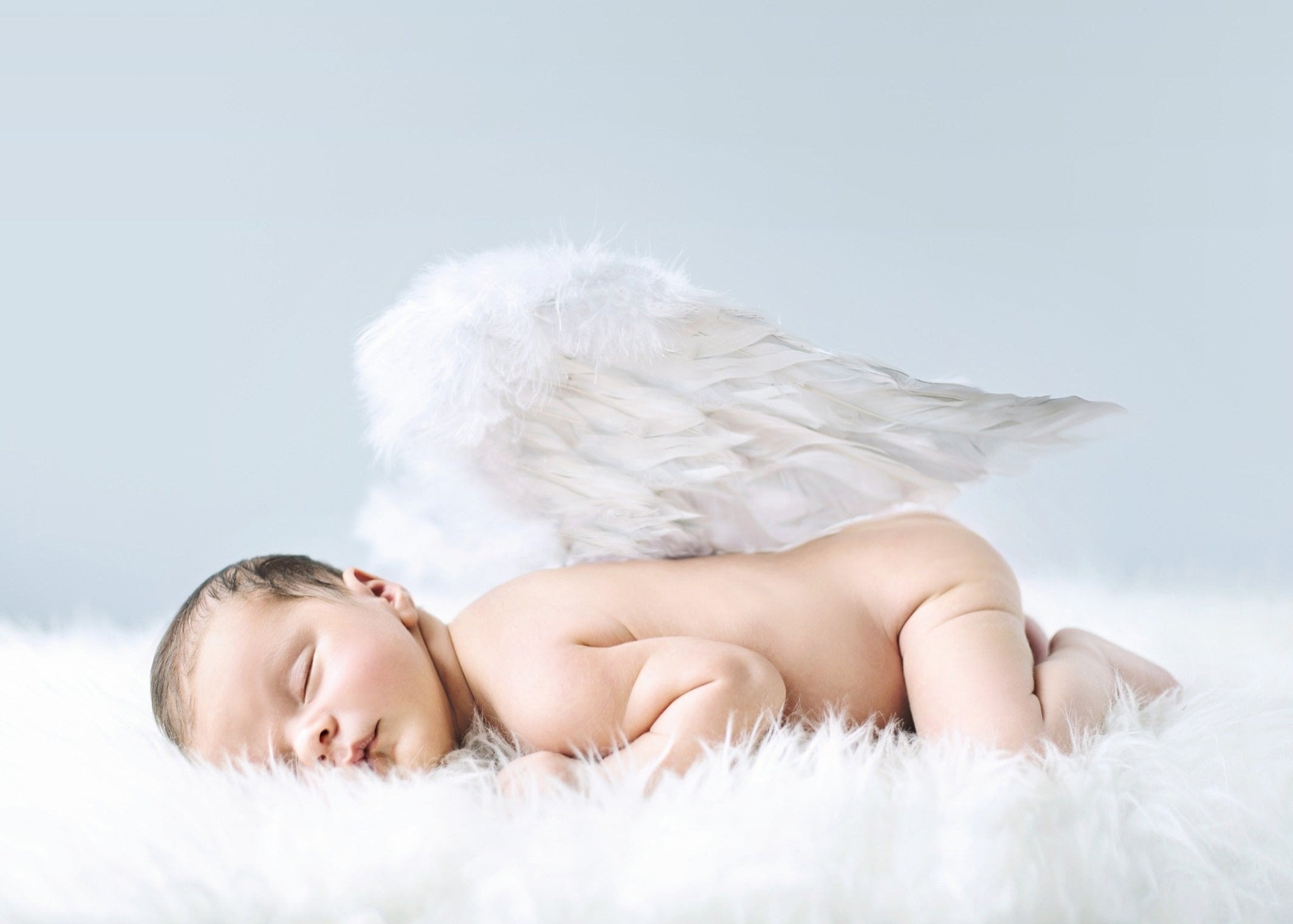 Slapende baby met witte engelenvleugels op zachte wolken achtergrond – symbool voor puurheid, bescherming en liefde – collectie Engelen.