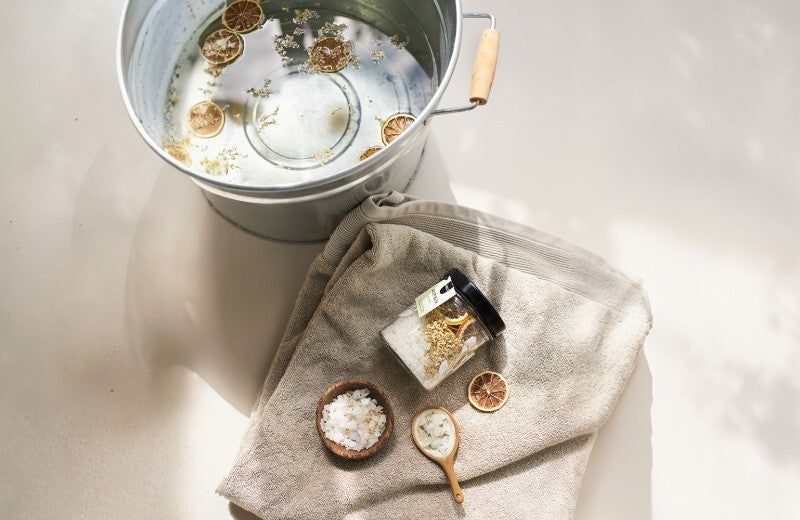 Pineut badthee met gedroogde bloemen en citrus – een natuurlijk verwenmoment voor in bad.