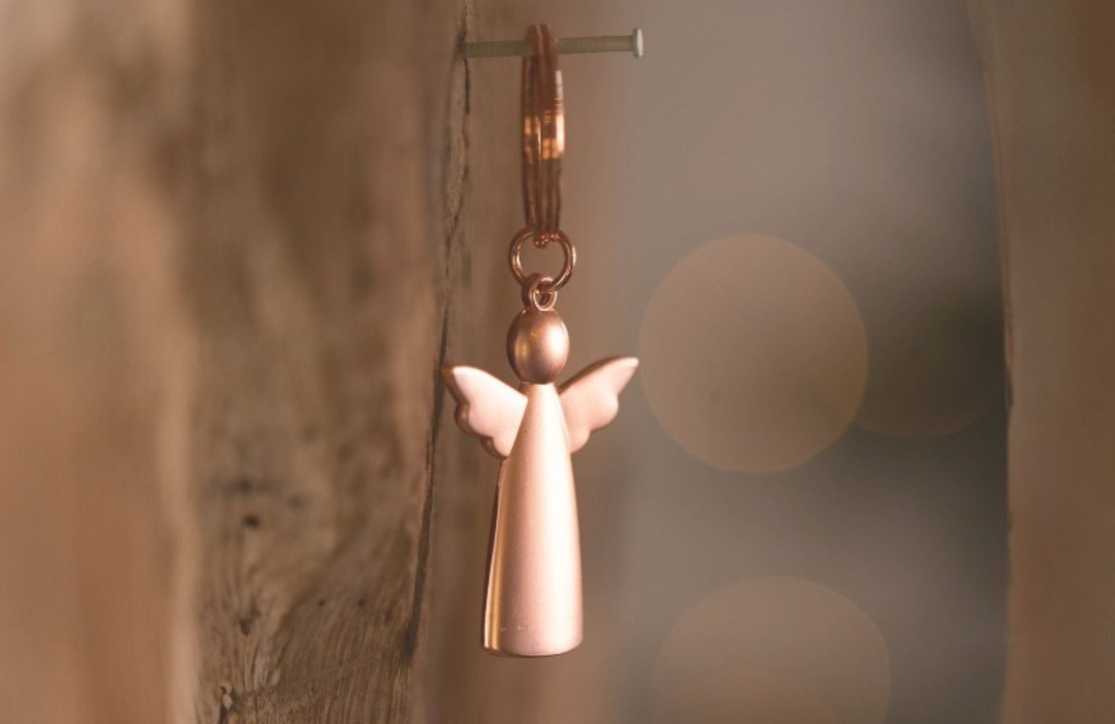 Sleutelhanger met koperkleurige engel als symbool van troost, bescherming of herinnering.