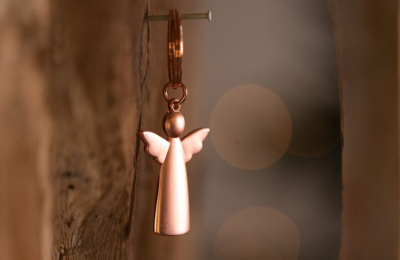 Sleutelhanger met koperkleurige engel als symbool van troost, bescherming of herinnering.