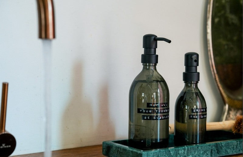 Wellmark bad- en doucheproducten – duurzame luxe in glazen flessen met stijlvolle tekstlabels.